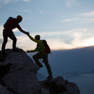 Scalatori che si aiutano a scalare la montagna